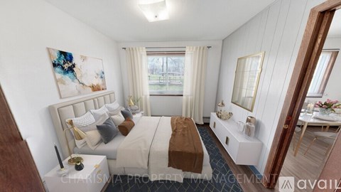 A bedroom with a large bed and a painting on the wall.