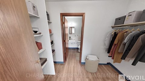 A hallway with a mirror and clothes hanging on the wall.