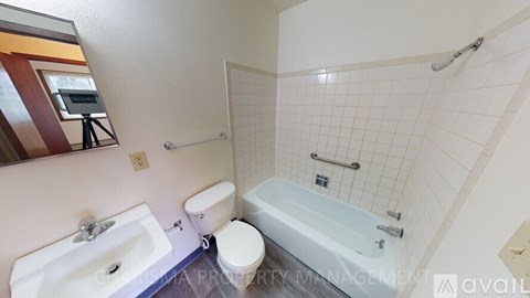 A white sink is in a bathroom with a white toilet and a white bathtub.