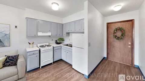 A kitchen with white appliances and a wooden door.