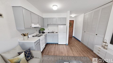 A kitchen with white cabinets and a wooden floor.