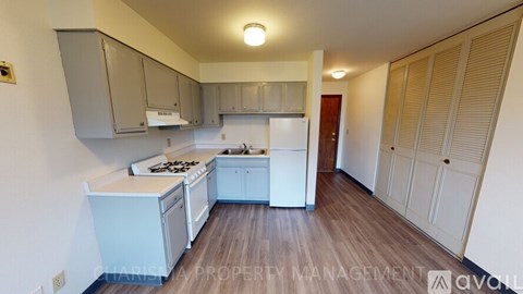 A kitchen with white appliances and wooden floors.
