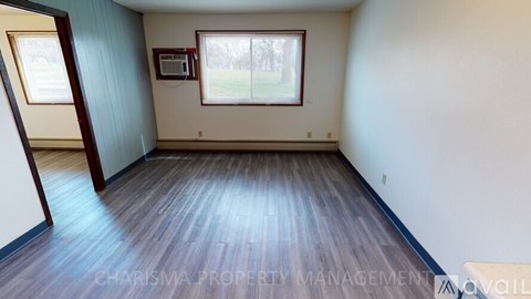 A room with wooden flooring and a window.