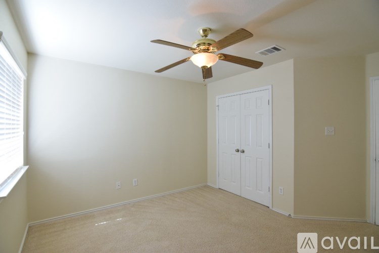 A room with a ceiling fan and two doors.
