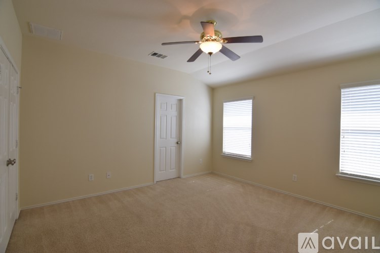 A room with a ceiling fan and two doors.