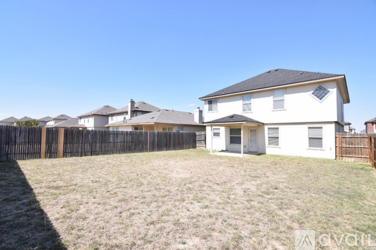 A white house with a brown fence in front of it.