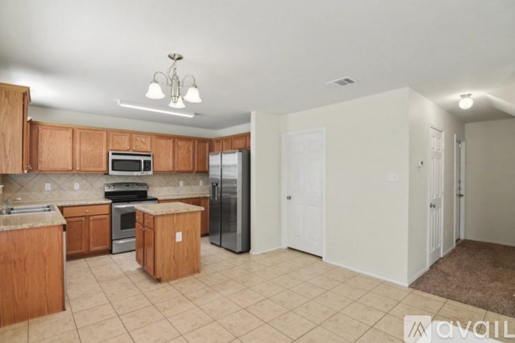 A spacious living room with a brown carpet and a ceiling fan.
