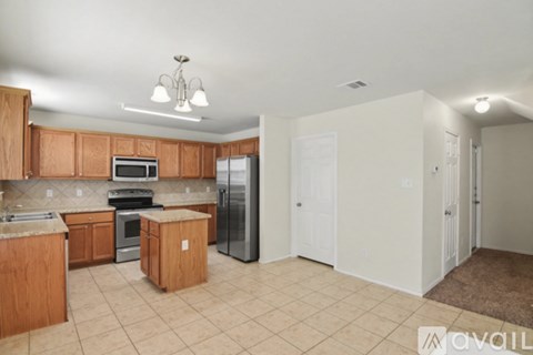 A spacious living room with a brown carpet and a ceiling fan.