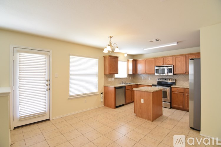 A kitchen with wooden cabinets and a tiled floor.
