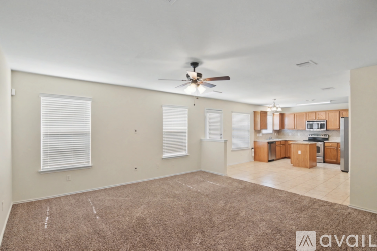 A spacious room with a ceiling fan and carpeted floor.