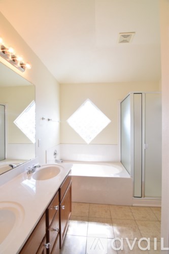 A bathroom with a sink, mirror, and a glass shower door.