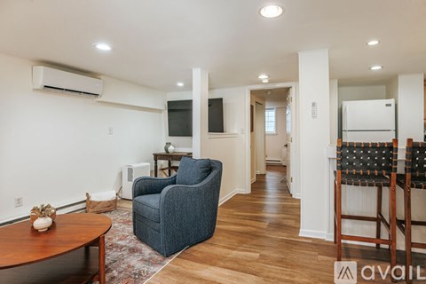 A living room with a blue chair and a wooden table.