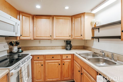 A kitchen with wooden cabinets and a white stove.