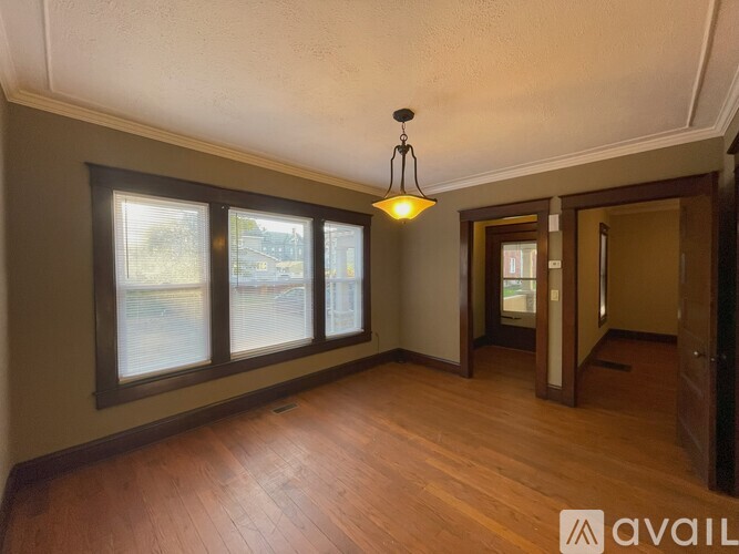 A room with a wooden floor and a brown door.