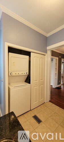 A kitchen with a black counter top and a white fridge.