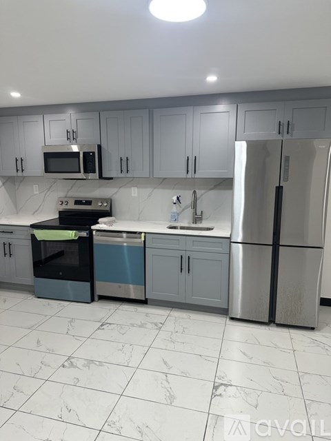 A kitchen with a stainless steel refrigerator, microwave, oven, and dishwasher.