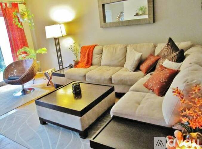 A living room with a television, a chair, a couch, and a coffee table.