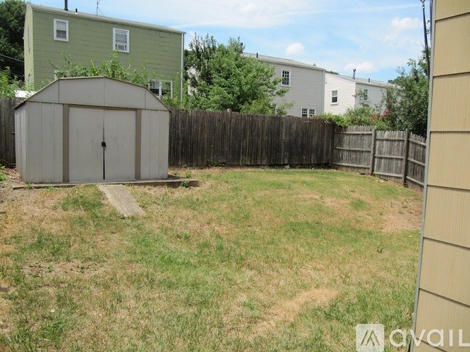A backyard with a shed and a fence.