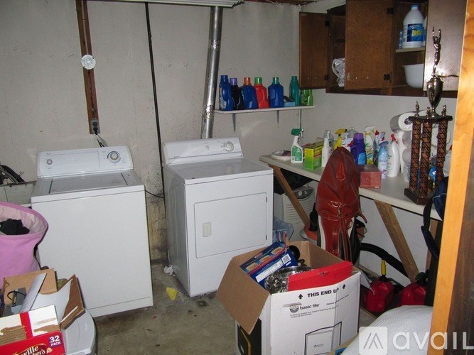 A room with a toilet, sink, and a lot of boxes and bottles.
