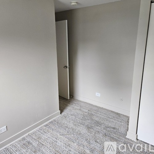 A room with a carpeted floor and a closed door.