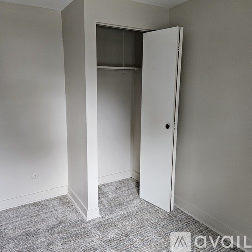 A white door is open in a room with grey carpet.