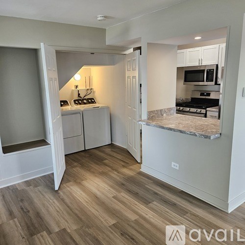 A kitchen with a wooden floor and white cabinets.