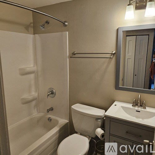 A bathroom with a toilet, sink, and shower.
