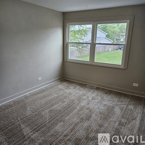 A room with a carpeted floor and a large window.