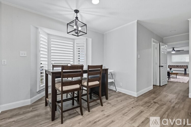 A dining room with a wooden table and chairs.