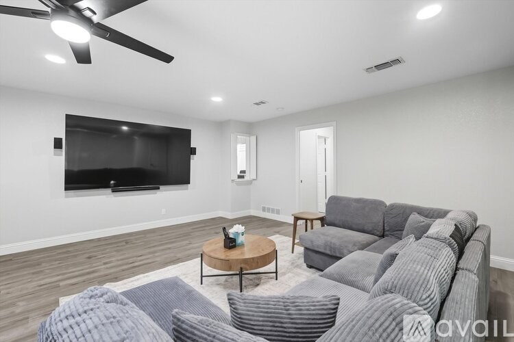 A living room with a grey couch and a television.