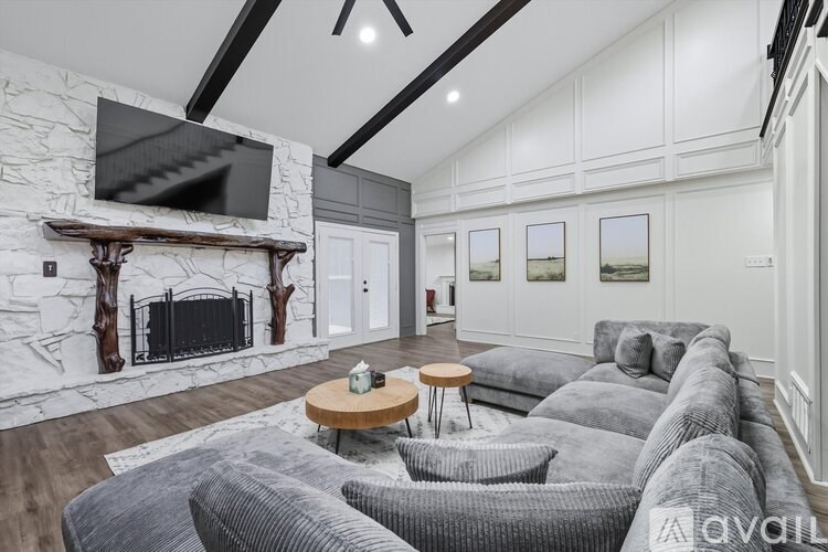 A living room with a grey couch and a fireplace.