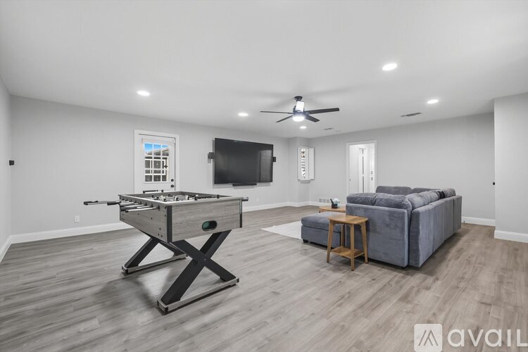 A spacious room with a pool table and a couch.