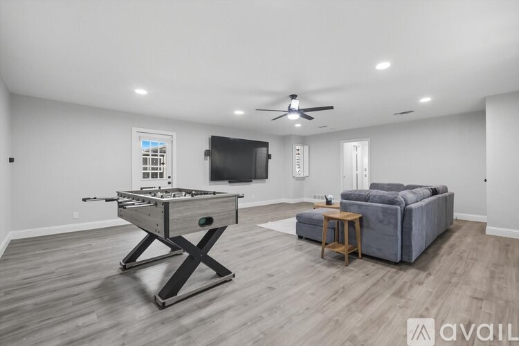 A spacious room with a pool table and a couch.