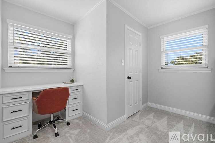 A room with a desk and a chair in it.