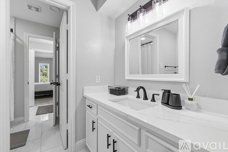 A bathroom with a white sink and a mirror above it.