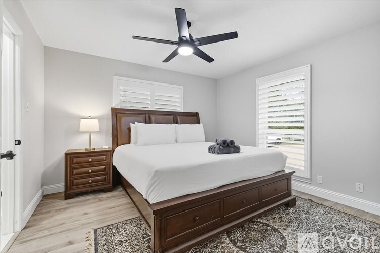 A bedroom with a bed, nightstand, and a ceiling fan.