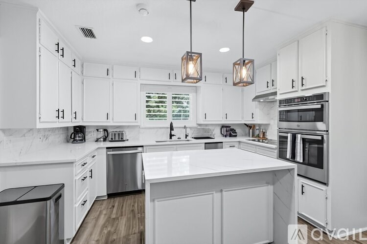 A modern kitchen with white cabinets and a large island.