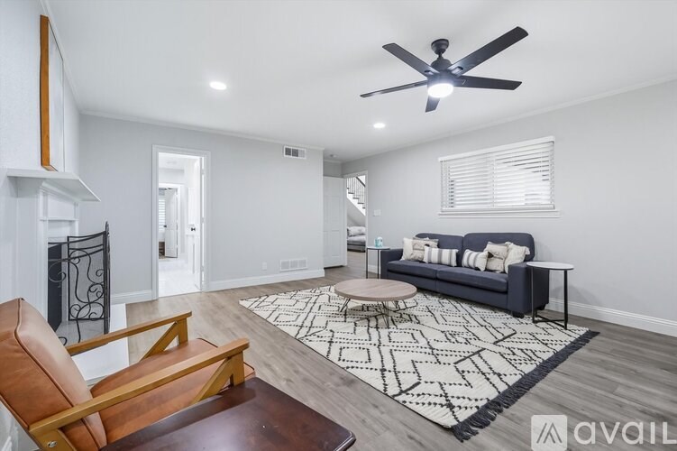 A living room with a black couch and a wooden chair.