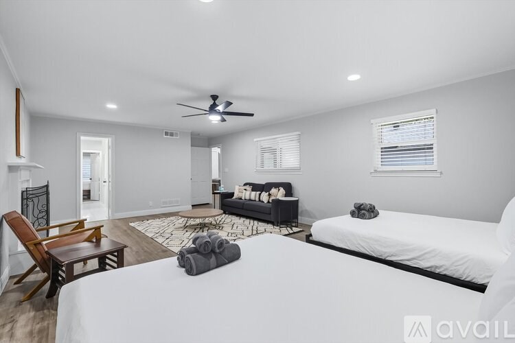 A bedroom with a large bed, a chair, and a rug.