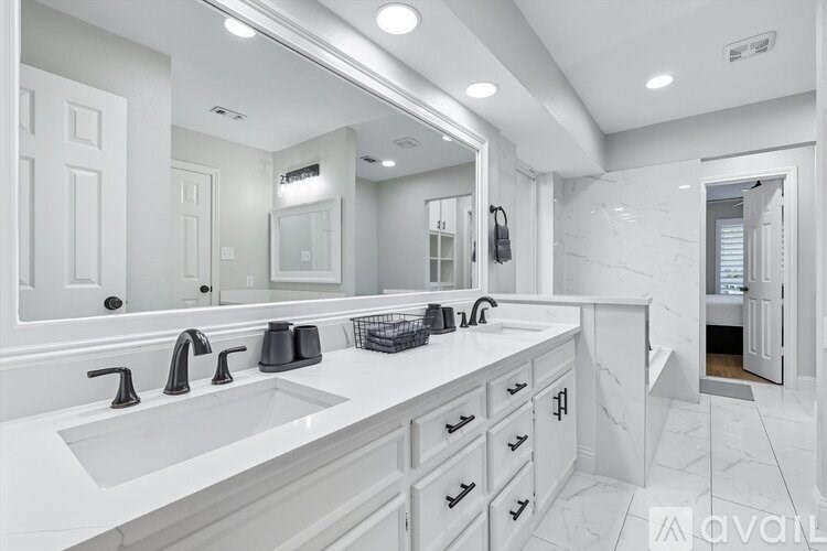 A bathroom with two sinks and a large mirror.