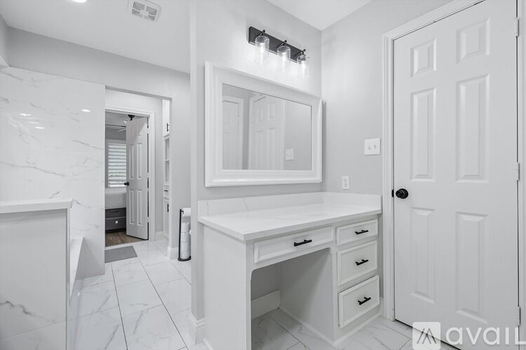 A white bathroom with a vanity and a mirror.