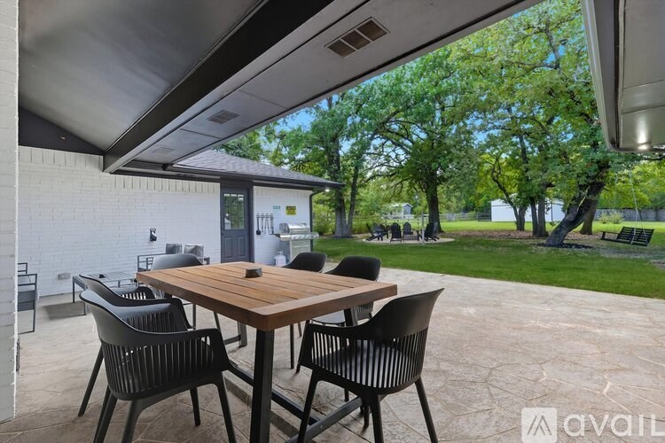 A patio with a table and chairs under a roof.