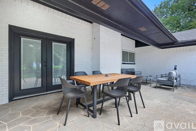 A patio with a table and chairs is set up outside a house.