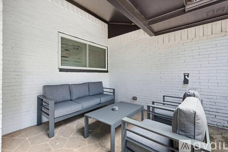 A grey sofa and table are on a patio.