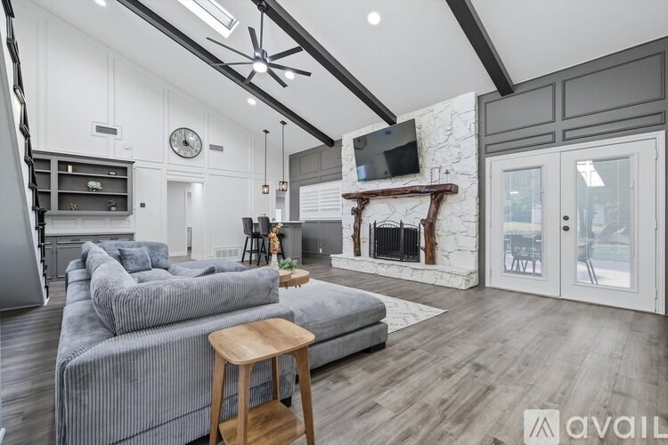 A modern living room with a grey sofa and a wooden stool.