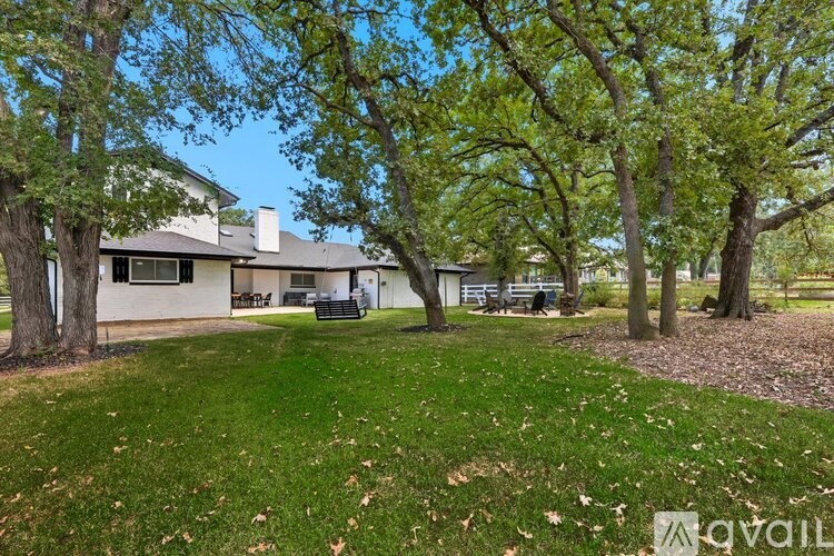 A house with a lawn and trees in front of it.