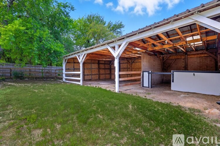A large outdoor garage with a white door and a white fence.