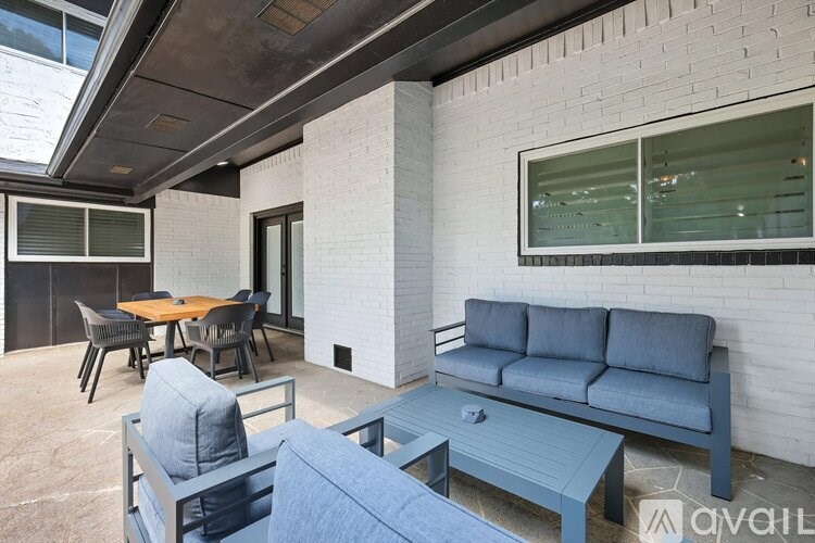 A modern outdoor seating area with a table and chairs.