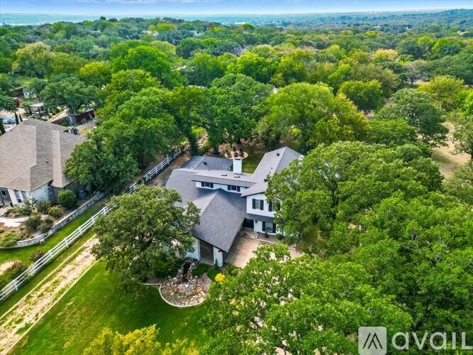A bird's eye view of a house surrounded by greenery.