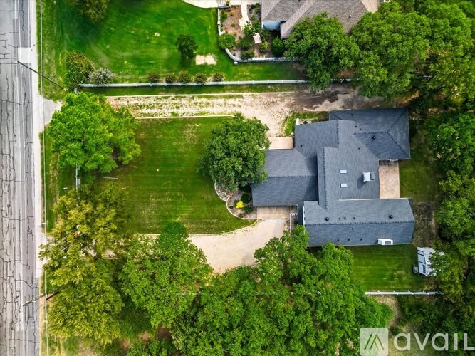 A house surrounded by trees and a grassy area.